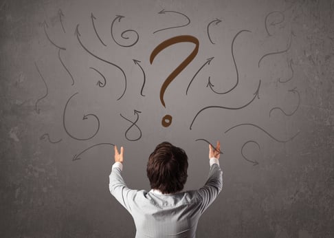 Business man looking at question mark sketch on the wall